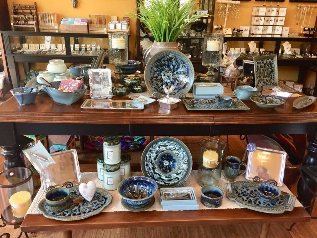 An assortment of decorative ceramic bowls and plates, candles and other gifts at Terra Culture Gifts.