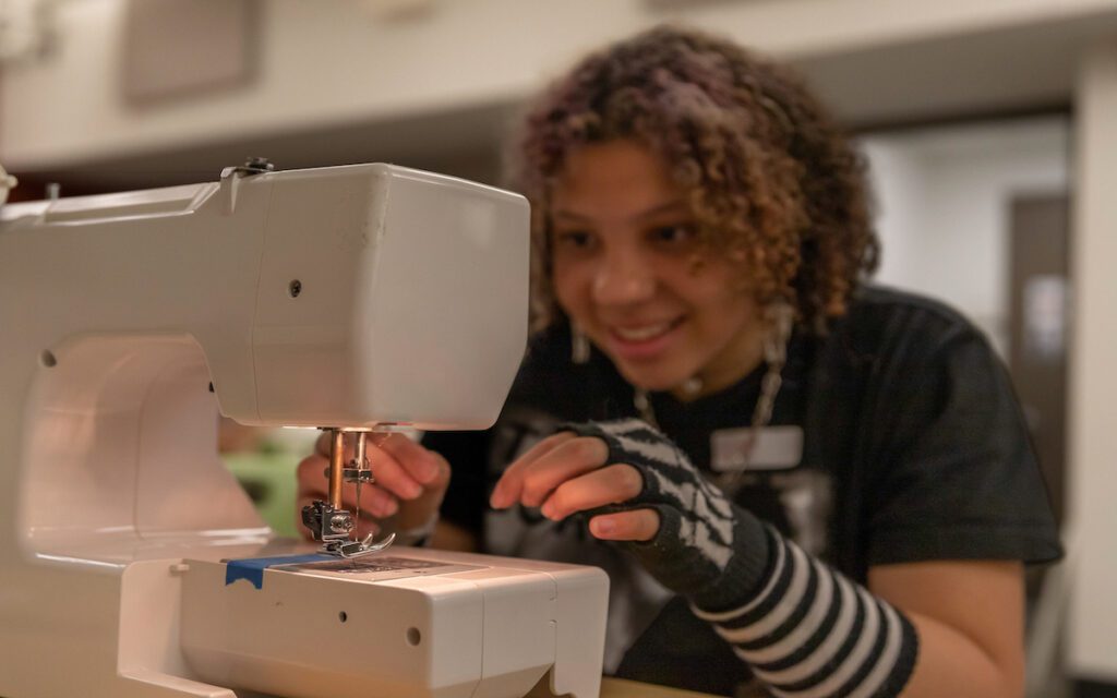 DEAN_Camp at sewing machine