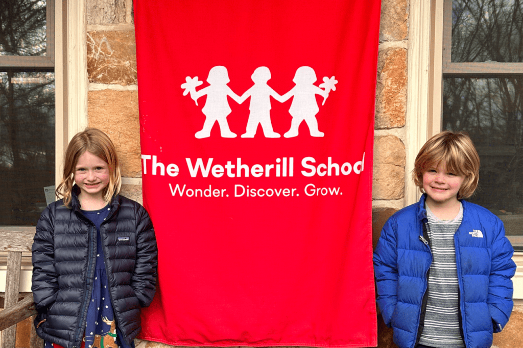 children standing with a school sign