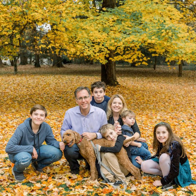 family of 6 and their dog in autumn leaves