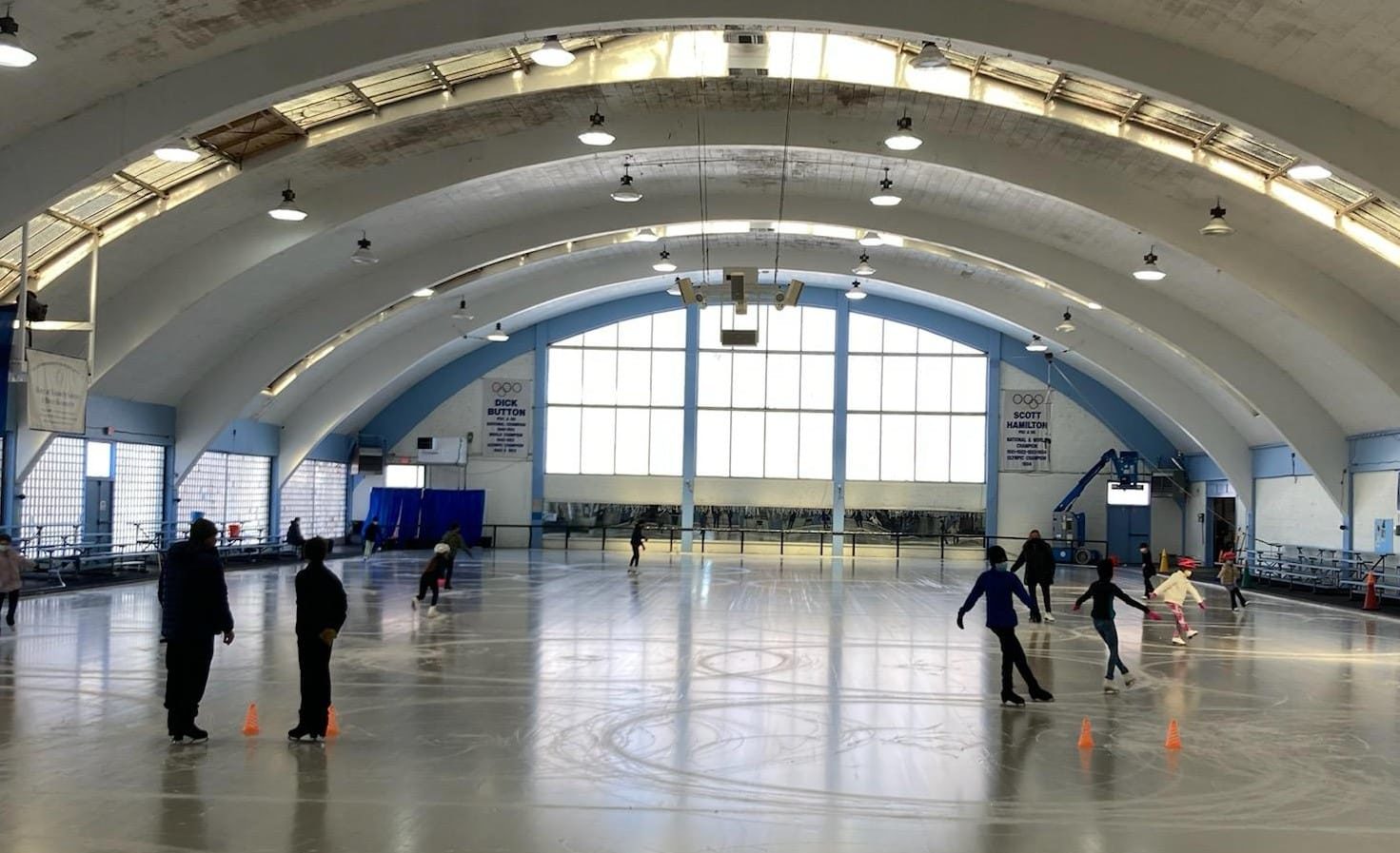 Large, open ice rink with a few skaters