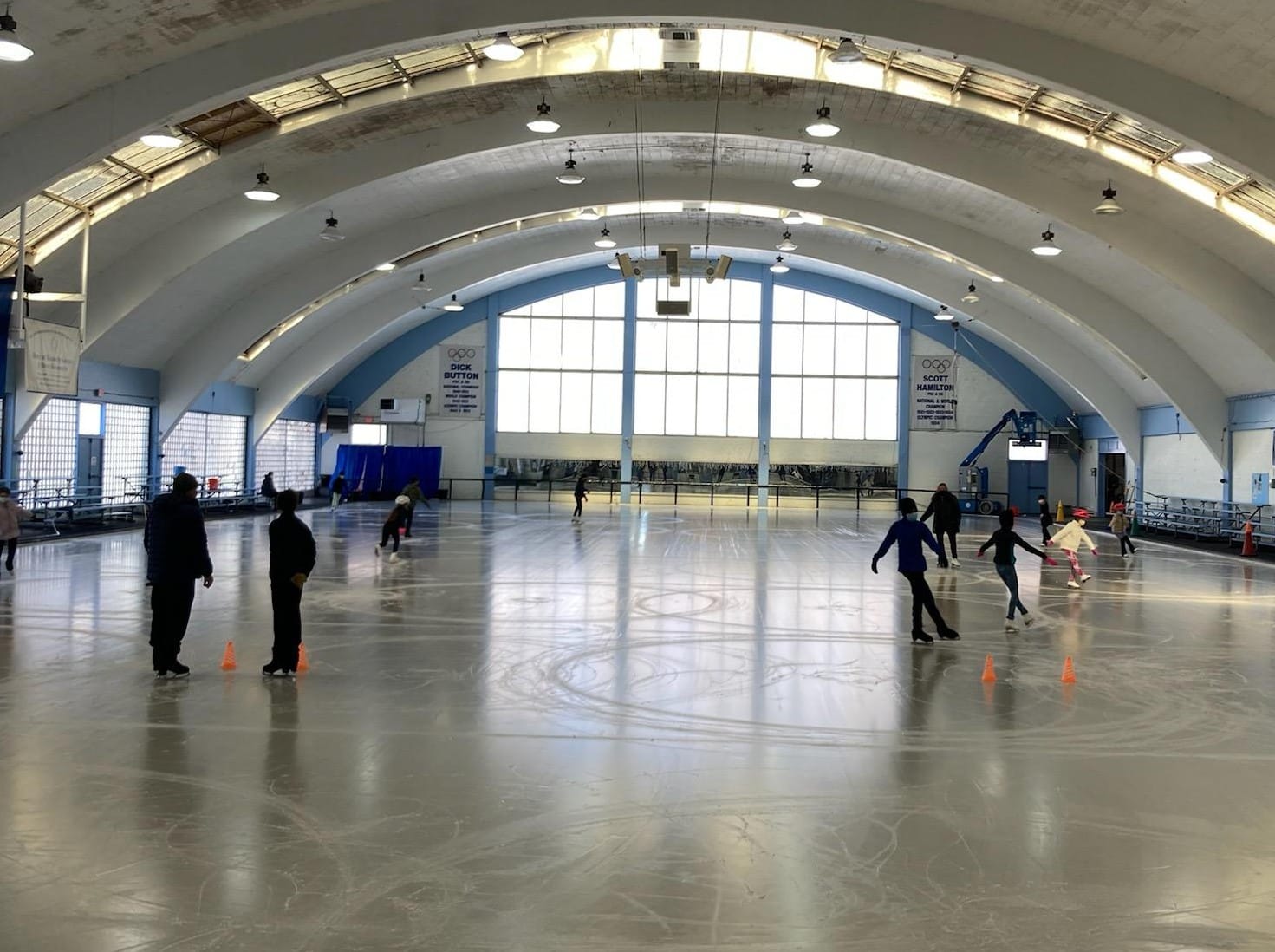 Large, open ice rink with a few skaters