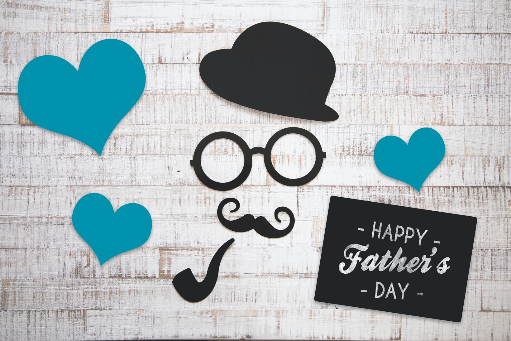 Paper cutouts of top hat, glasses, mustache and pipe to represent dads on Father's Day.