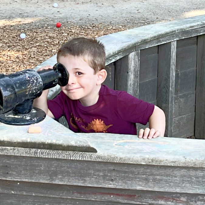boy on a playground with a telescope