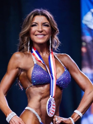 Maria Rossi Fitness Instructor with a winning medal from a competition