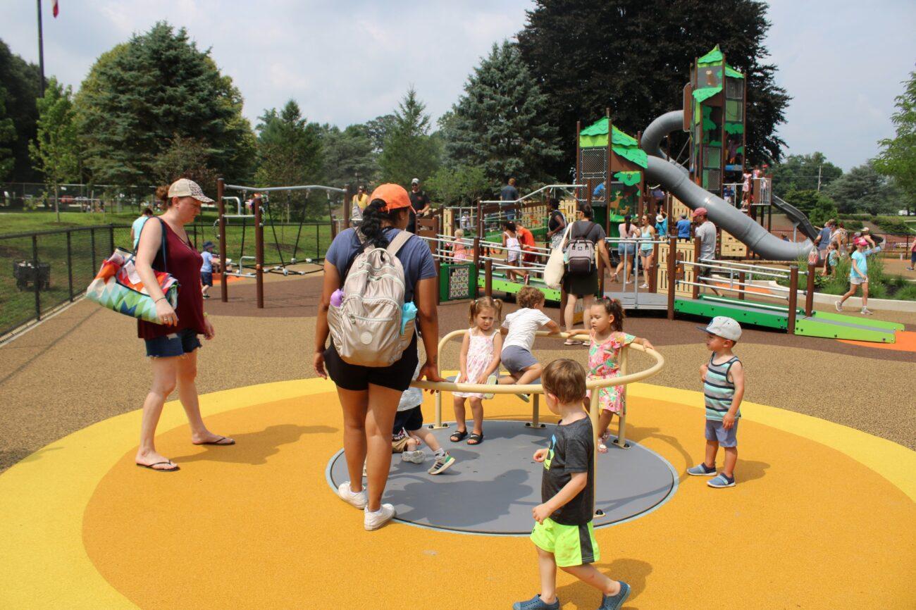 Kids play on the accessible spinner at Rose Tree Park's accessible playground in Media.