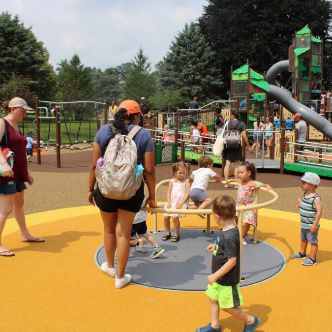 Kids play on the accessible spinner at Rose Tree Park's accessible playground in Media.