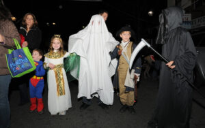 Kids in ghost, Egyptian, and patriot costumes with adults on the street in Narberth PA at night by 2010 Donald D. Groff