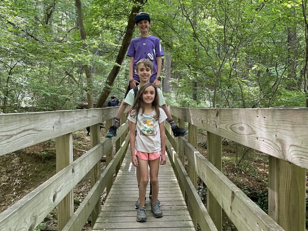 three siblings taking a hike on the Riverbend campus of Cupola Academy