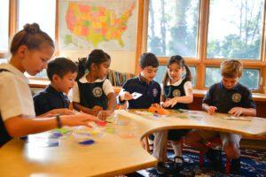 students learning around a table at MLCA