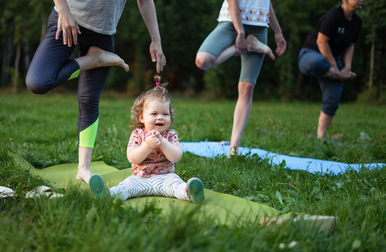 family fitness with parents doing yoga and baby on mat