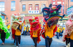 Chinese Suns in dragon costumes perform for Lunar New Year in Chinatown street Philadelphia