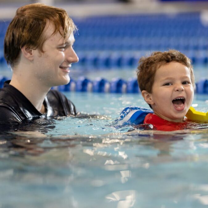Swim instructor with a child in the pool for a swim lesson