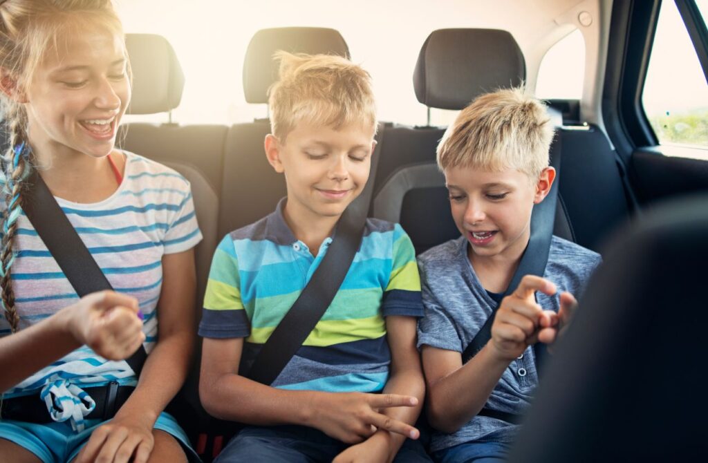 Kids playing games in car during road trip make travel fun.