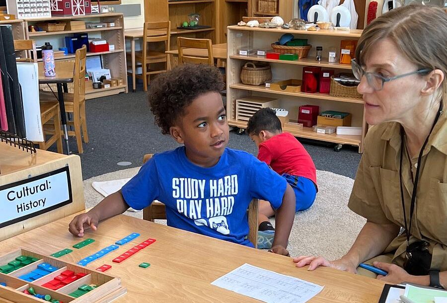 Montessori student working with a teacher with math blocks