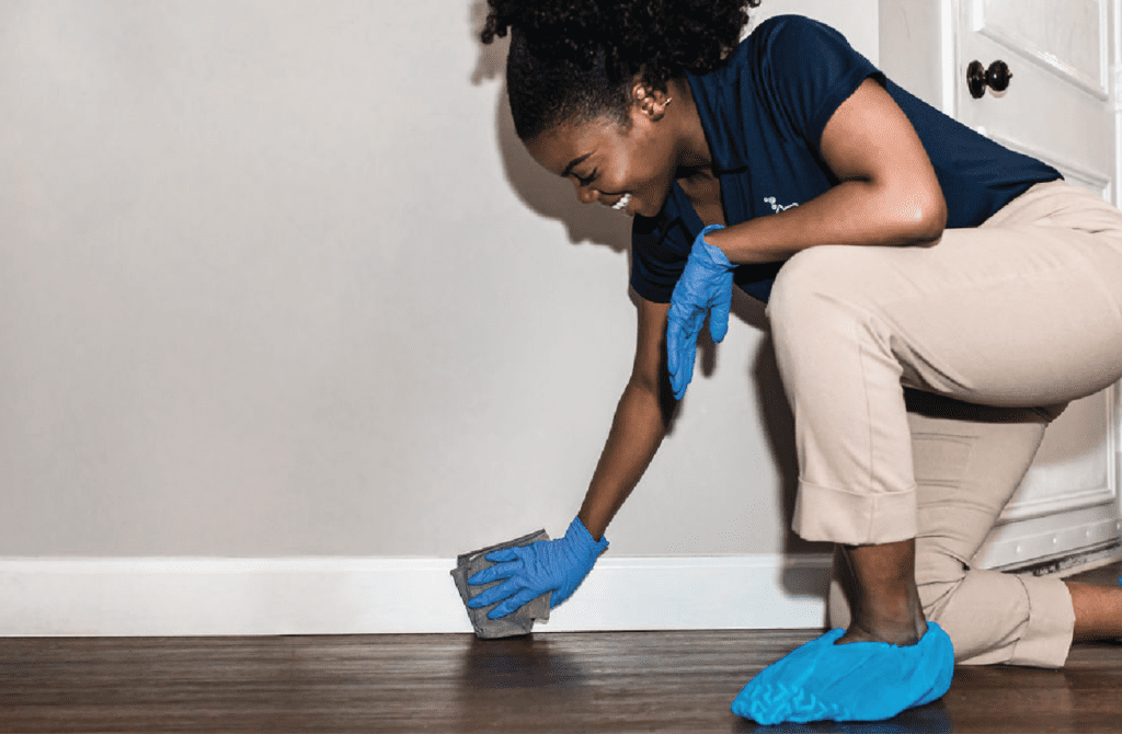 home cleaning employee wiping baseboards