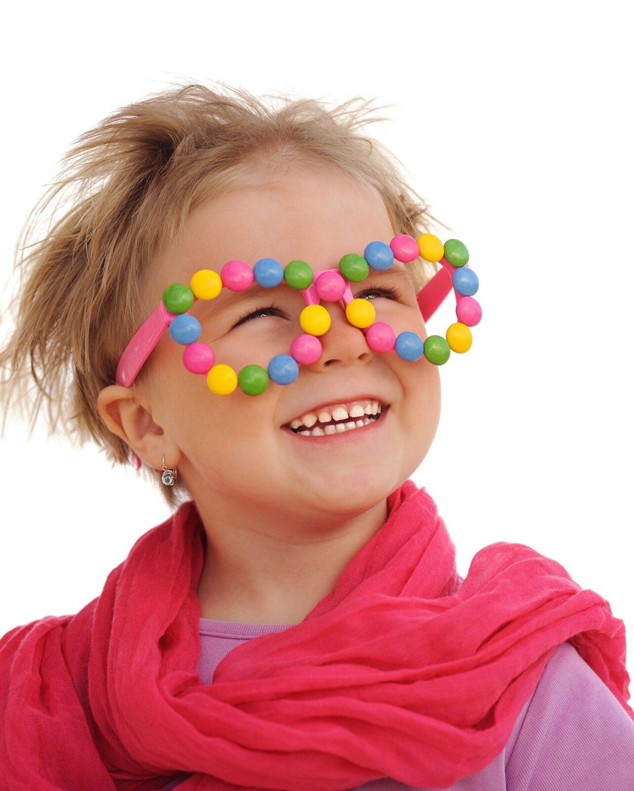 Portrait of cute little girl wearing funny glasses sweets smarties