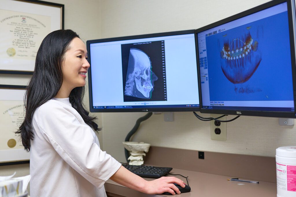 Dr Yang viewing dental xrays on a computer screen
