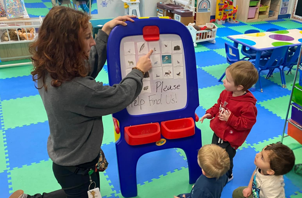 teacher showing preschool students pictures on an easel