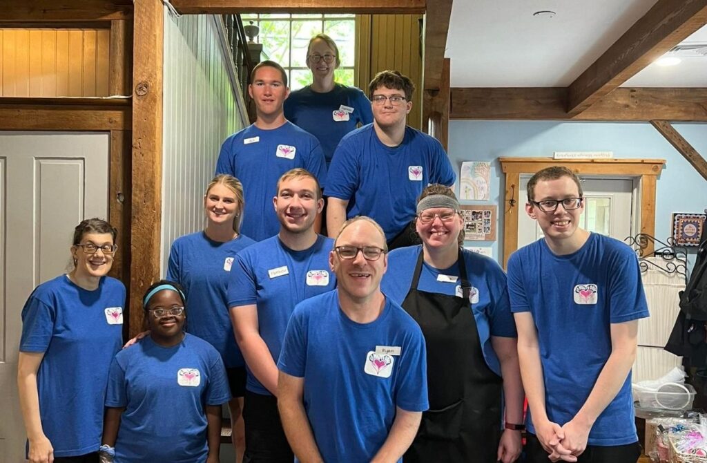 Ten employees of all abilities pose for a photo at So Much to Give Cafe. 