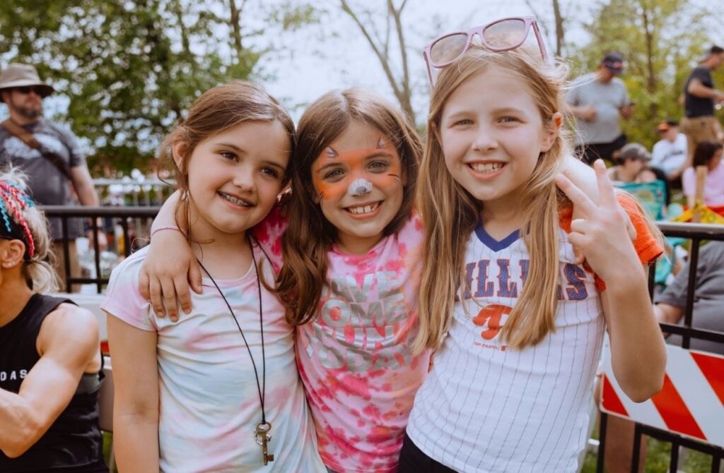 Three elementary school girls smile arm-in-arm in Pottstown.