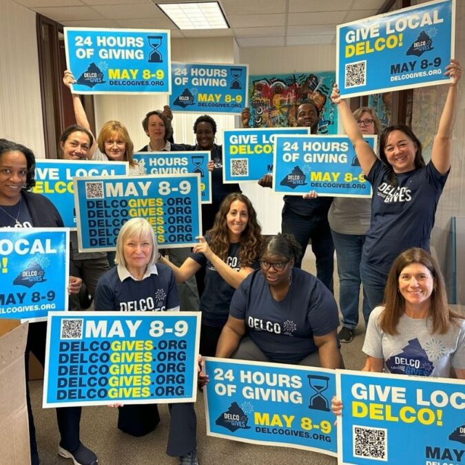 The Foundation for Delaware County staff hold signs for Delco Gives.