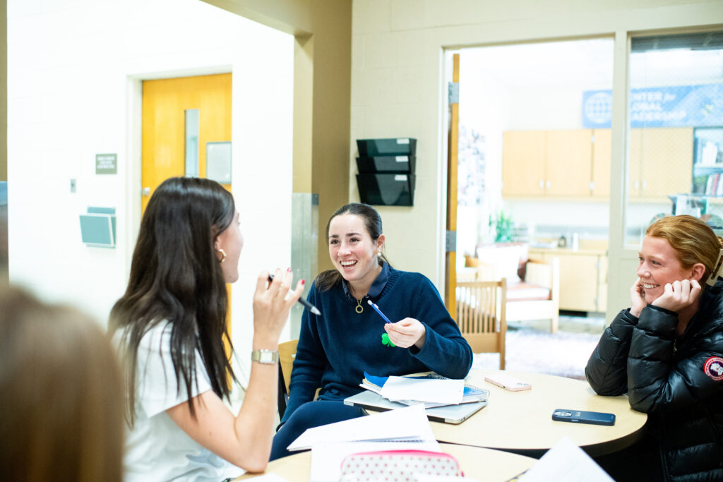 Academy of Notre Dame staff working with students at a table