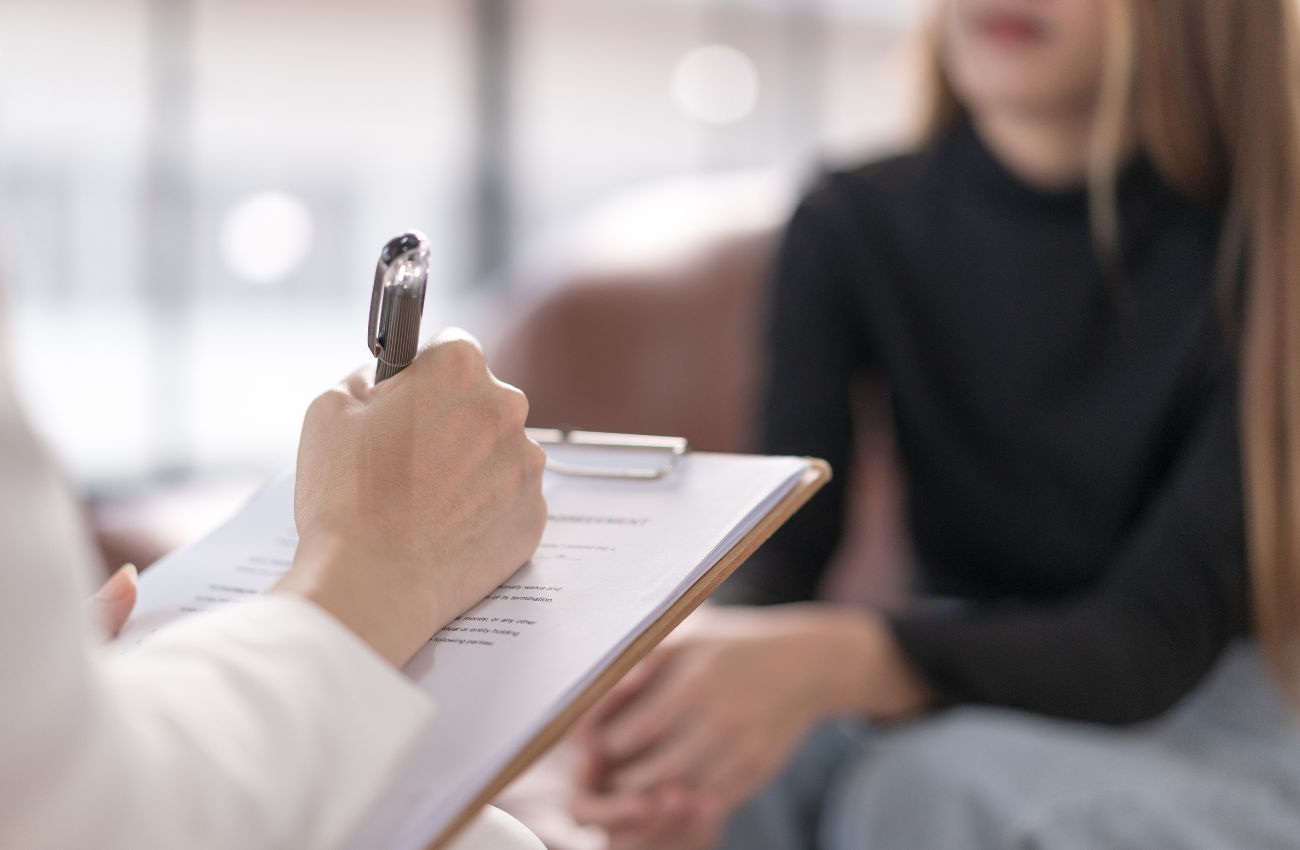 Doctor filling out an intake form with a patient
