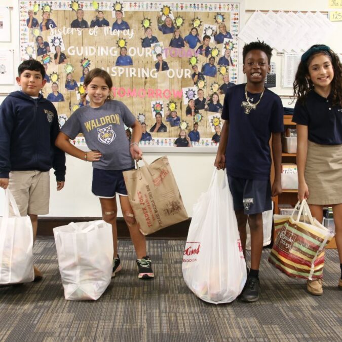 Waldron Mercy students holding bags as part of their service learning program.