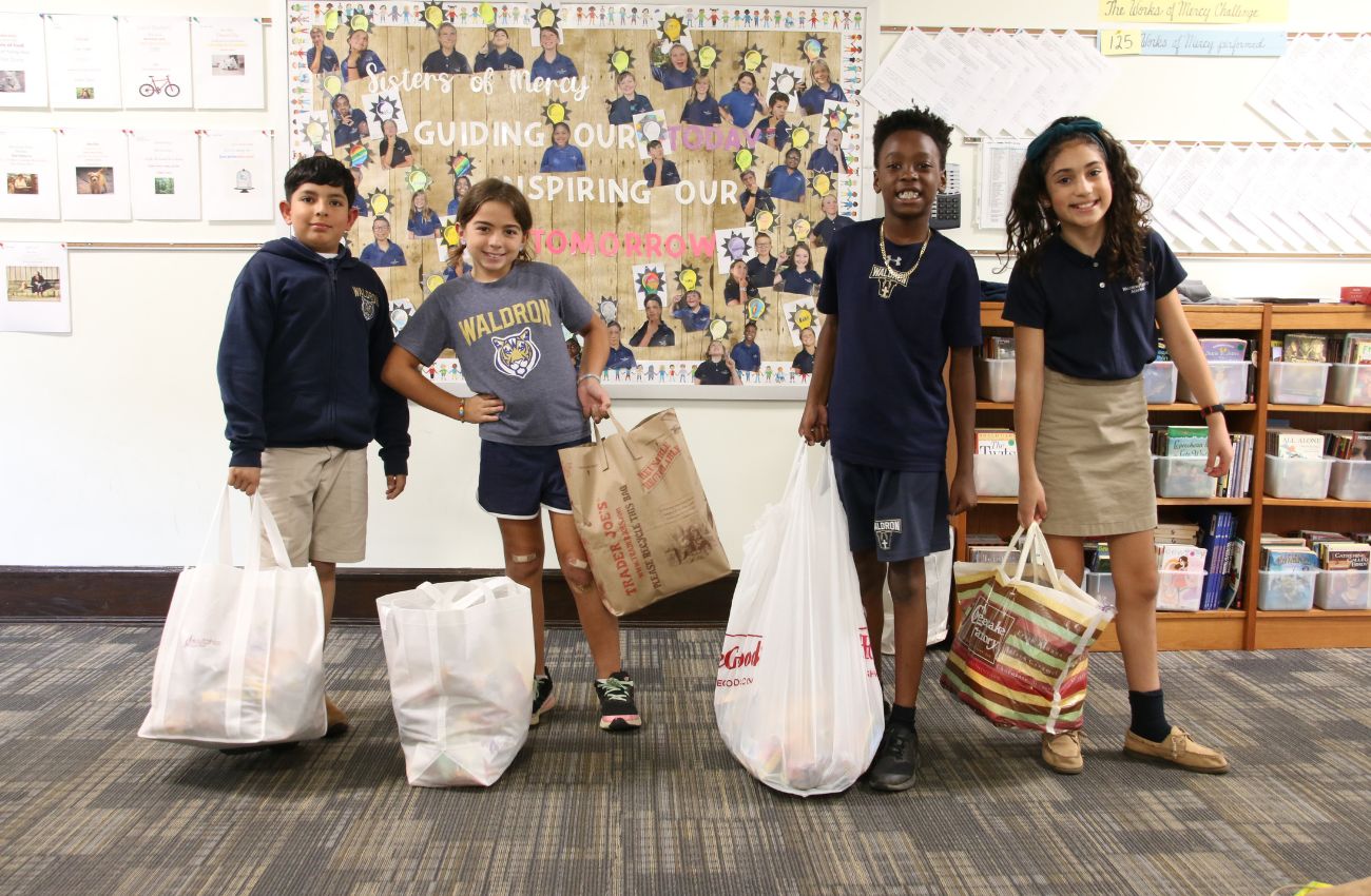 Waldron Mercy students holding bags as part of their service learning program.