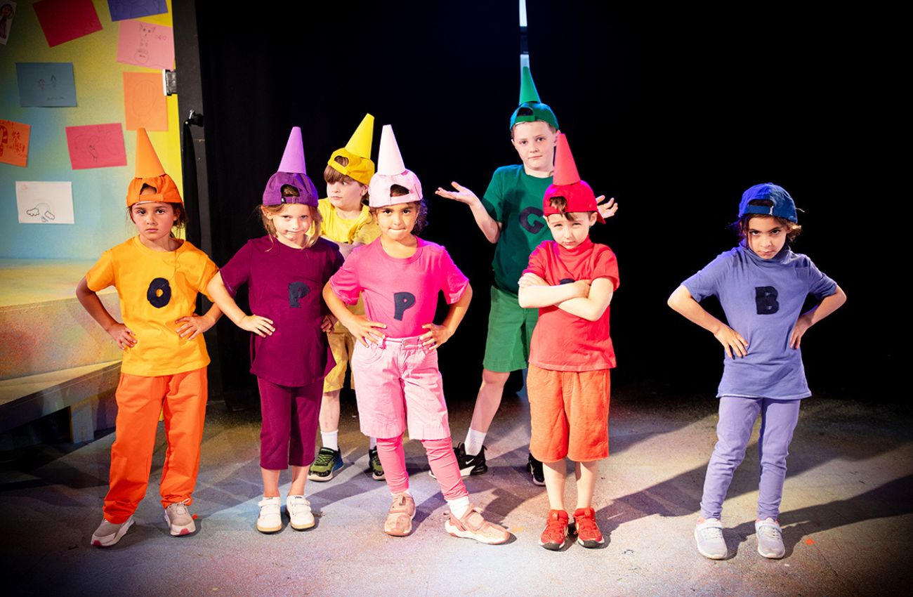 Wolf PAC performers dressed as multicolored crayons in a children's theater production.