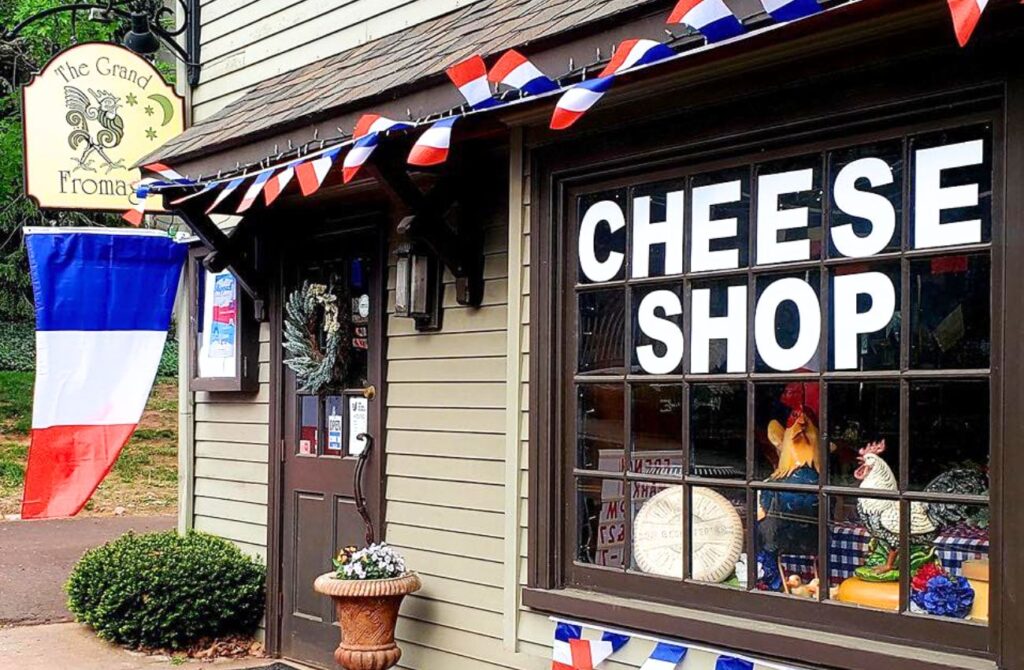 A specialty cheese shop with French flags sits along the main shopping street in Skippack Village.