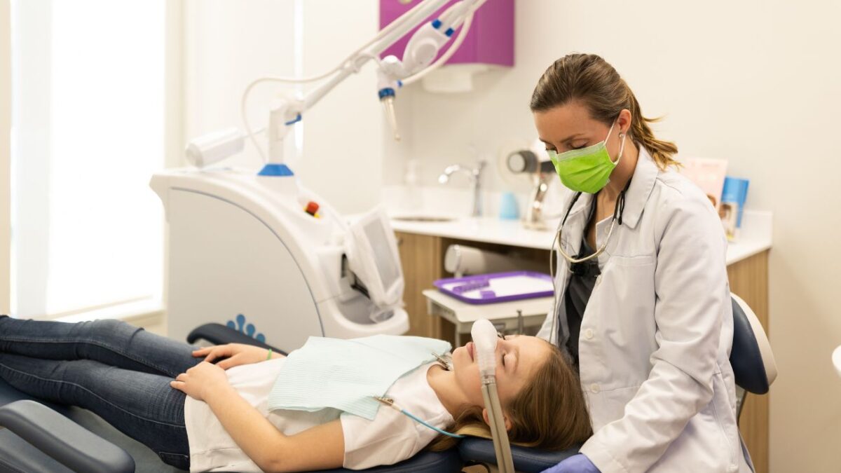 Dr. Jackie Wingate a pediatric orthodontist sits with a young patient.