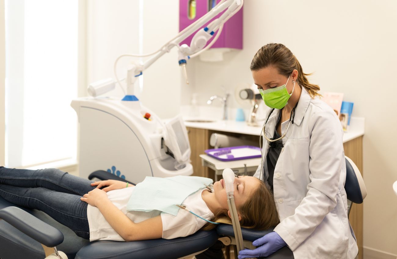 Dr. Jackie Wingate a pediatric orthodontist sits with a young patient.