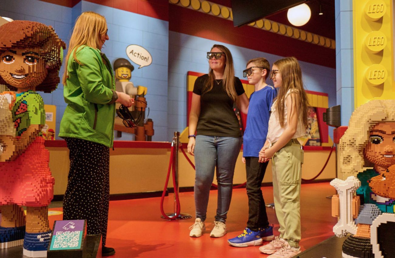 A mom and two kids wear special glasses to watch a 4D movie at Legoland Discovery Center.