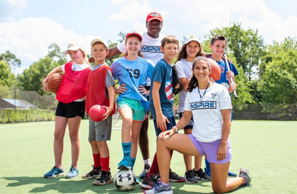 ESF Campers posing with sports balls on a turf field