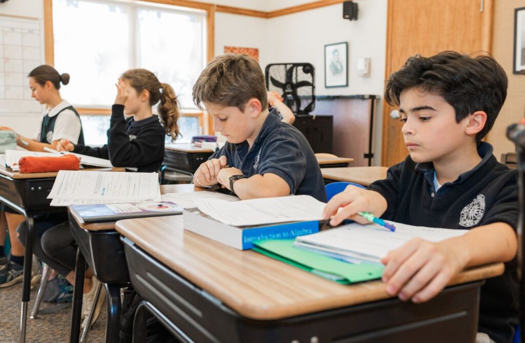 A small class of students work with textbooks at Main Line Classical Academy. 