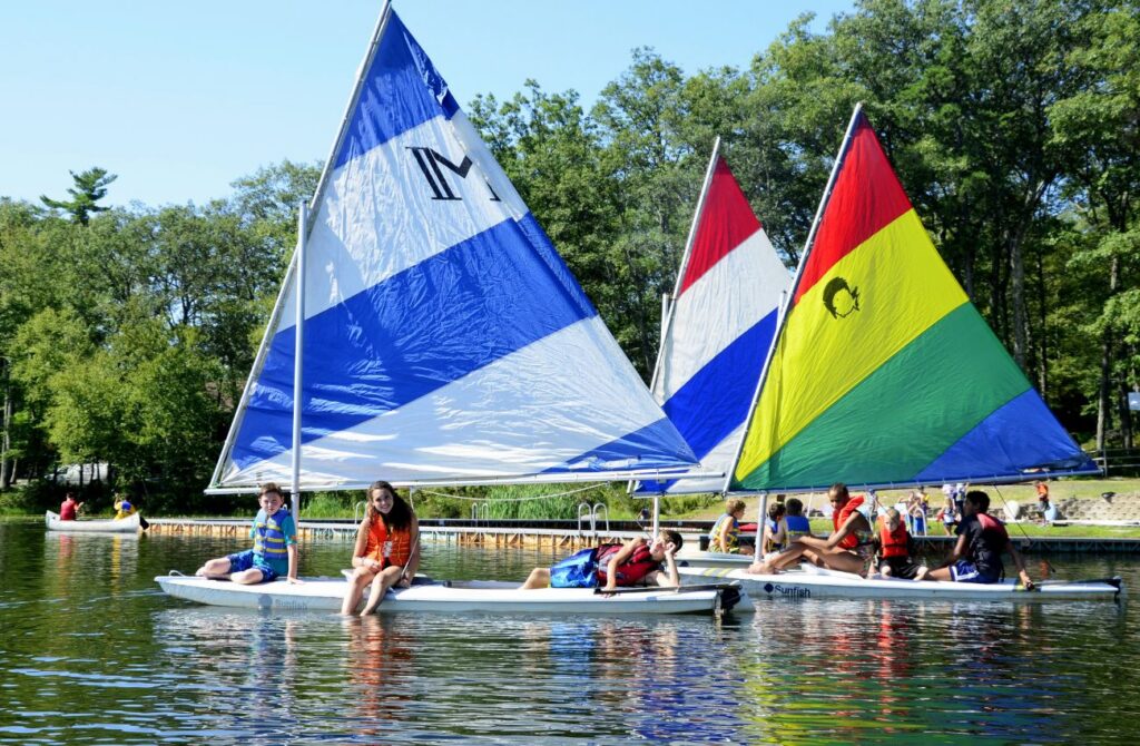 Campers sit on sailboats on the lake at Camp Speers YMCA.