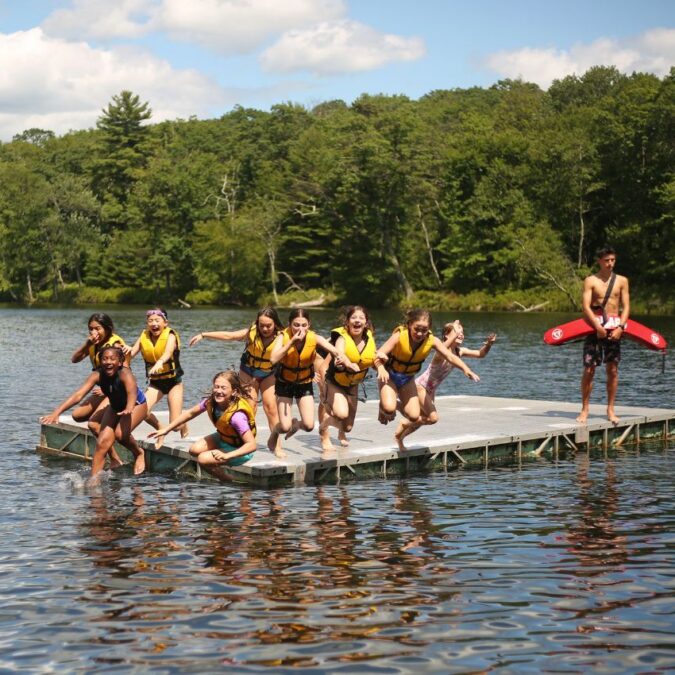 Campers jump off a float in the lake at Camp Speers YMCA.