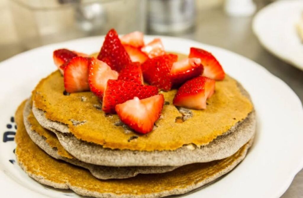 A stack of buckwheat pancakes topped with strawberries at Uncle Bill's Pancake House. 