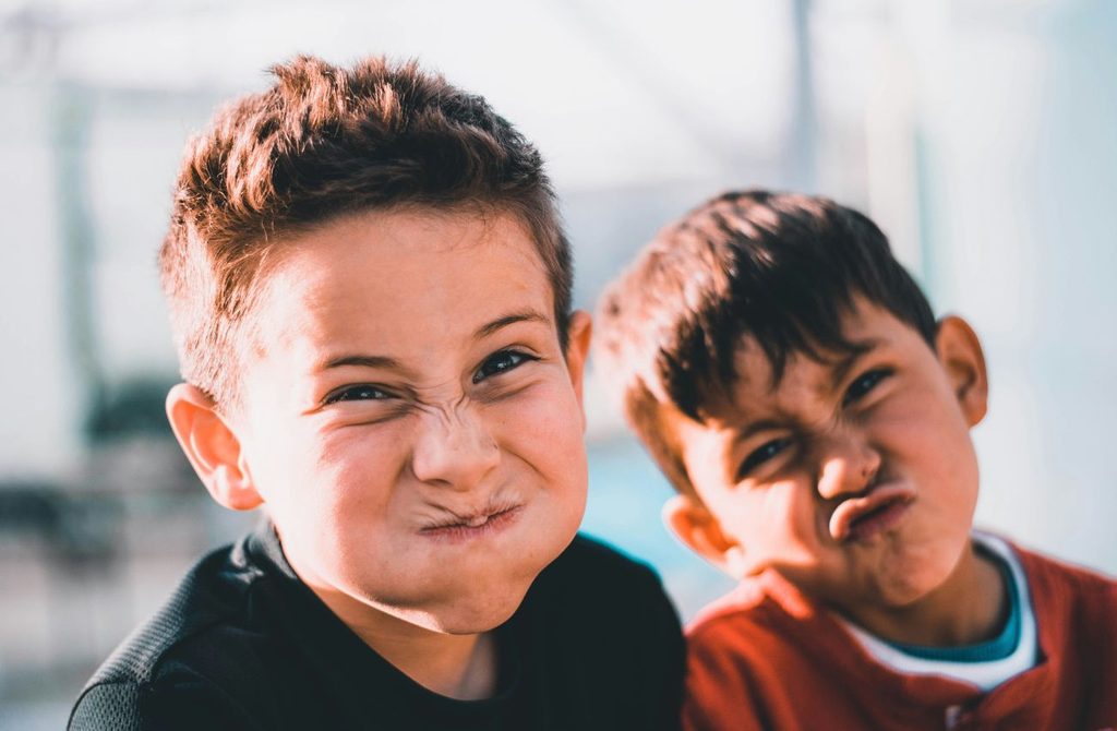 Two elementary school boys make faces for the camera. 