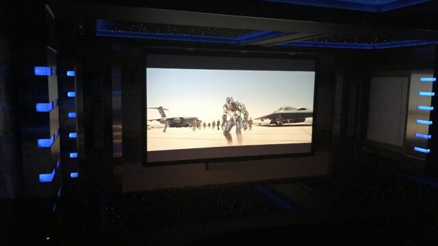 Home theater with ambient blue ceiling and wall lighting and star wars playing on the wall mounted large television JL Entertainment installation teen hang out