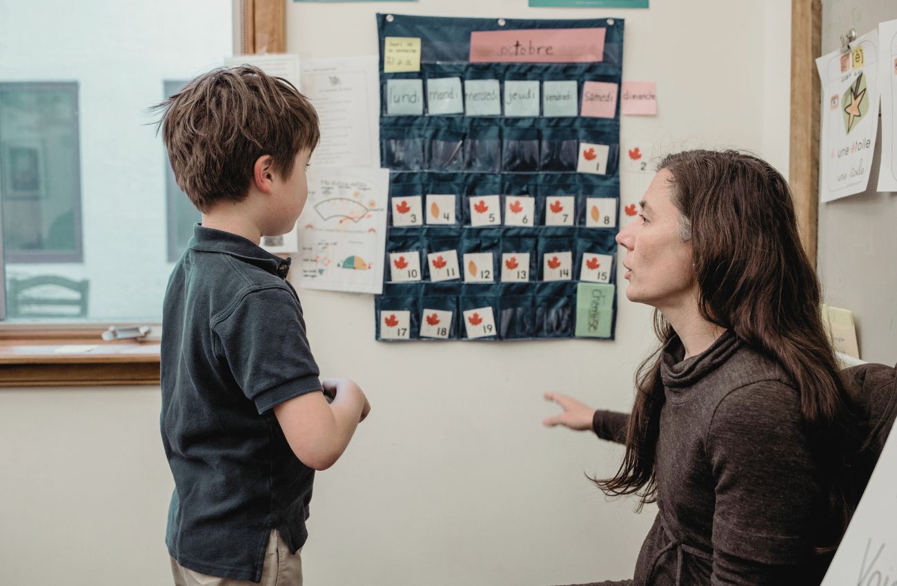 Teacher working with a student on a calendar activity.